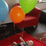 Bebe jugando con globos